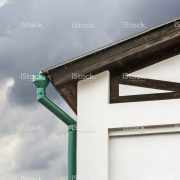 stock-photo-91348025-corner-of-house-with-green-metal-drainpipe
